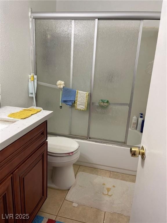 full bathroom featuring tile patterned flooring, vanity, bath / shower combo with glass door, and toilet