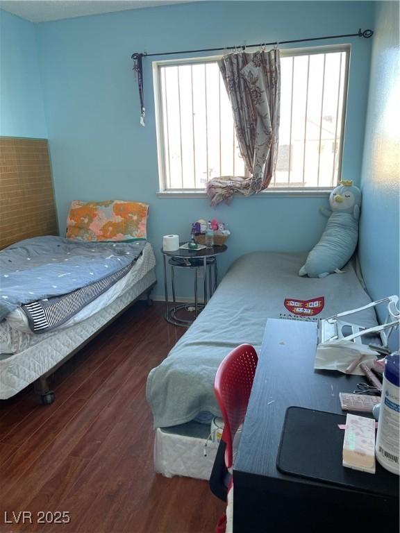 bedroom with dark hardwood / wood-style flooring