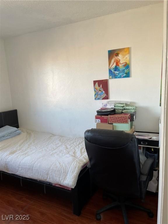 bedroom with dark hardwood / wood-style floors