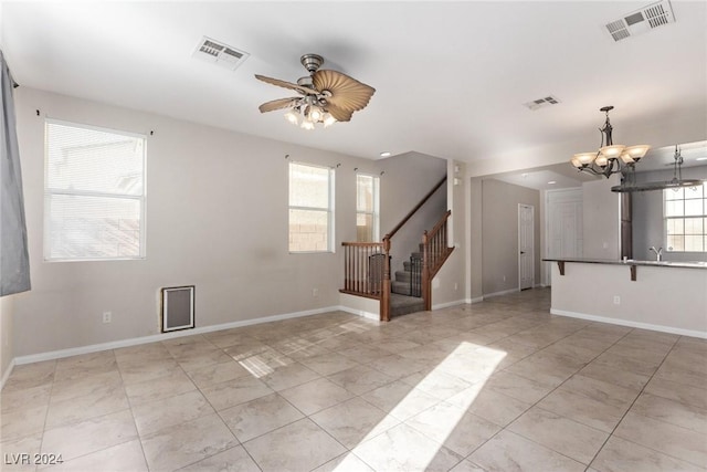 spare room with ceiling fan with notable chandelier and sink