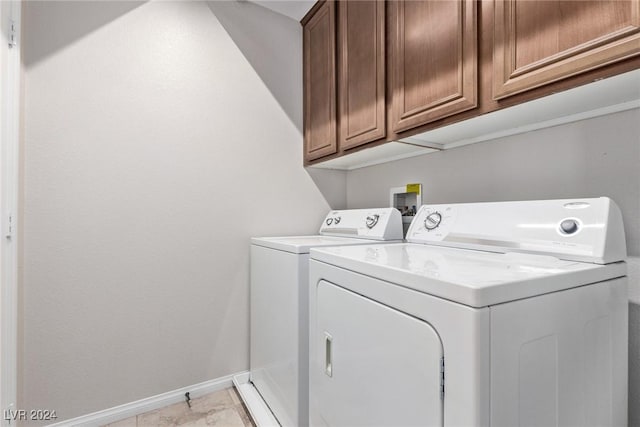 laundry area featuring cabinets, independent washer and dryer, and light tile patterned flooring