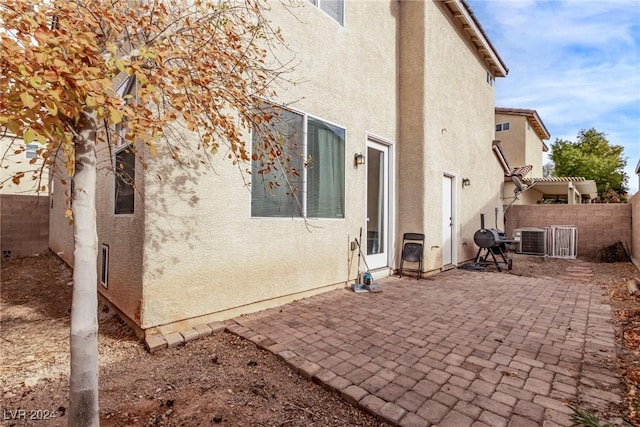 view of side of home with a patio and central AC