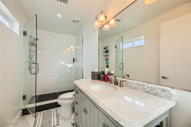 bathroom with vanity, toilet, and a shower with shower door