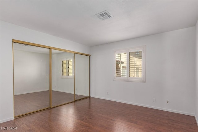 338 Jett St Unit 101, Las Vegas, NV 89145 - unfurnished bedroom featuring multiple windows, wood finished floors, and a closet