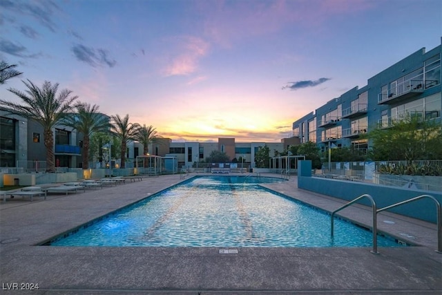 community pool with a patio and fence
