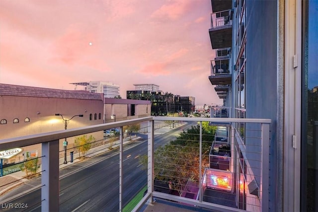 balcony at dusk featuring a city view