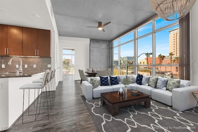 living area featuring expansive windows, ceiling fan, dark wood-style flooring, and a view of city