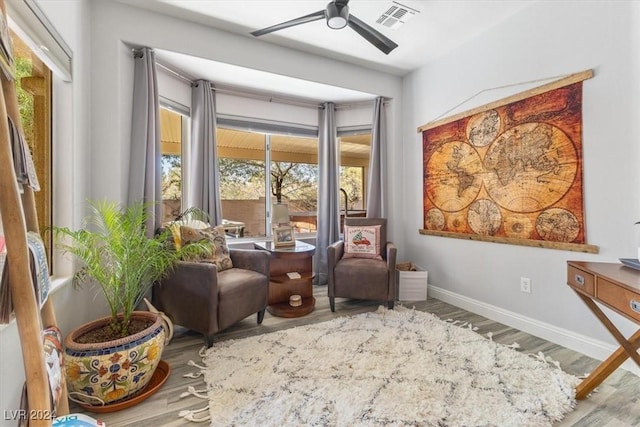 living area featuring light hardwood / wood-style flooring and ceiling fan