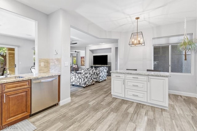 kitchen featuring decorative light fixtures, white cabinetry, sink, stainless steel dishwasher, and light hardwood / wood-style flooring