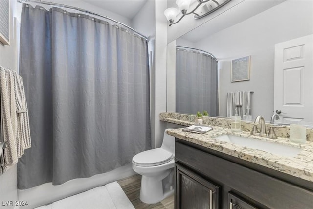 bathroom featuring vanity, curtained shower, wood-type flooring, and toilet