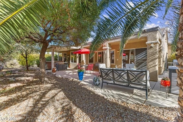 exterior space with a hot tub, a patio, and an outdoor hangout area