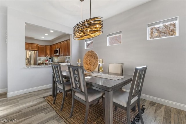 dining area with sink and light wood-type flooring