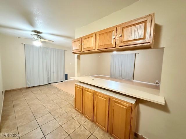 kitchen with light tile patterned floors, ceiling fan, and light countertops