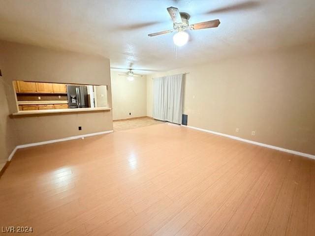 unfurnished living room with a ceiling fan, baseboards, and light wood finished floors