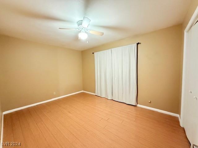 unfurnished room with light wood-style flooring, baseboards, and a ceiling fan