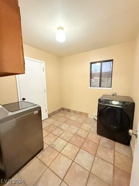 laundry room featuring laundry area, independent washer and dryer, and light tile patterned floors