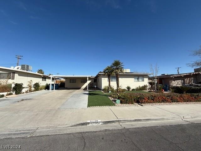 view of front of house with concrete driveway and a carport