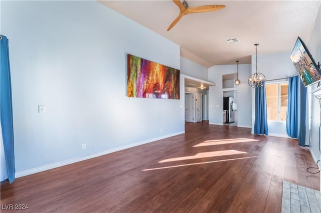 interior space featuring ceiling fan with notable chandelier, dark hardwood / wood-style flooring, and lofted ceiling