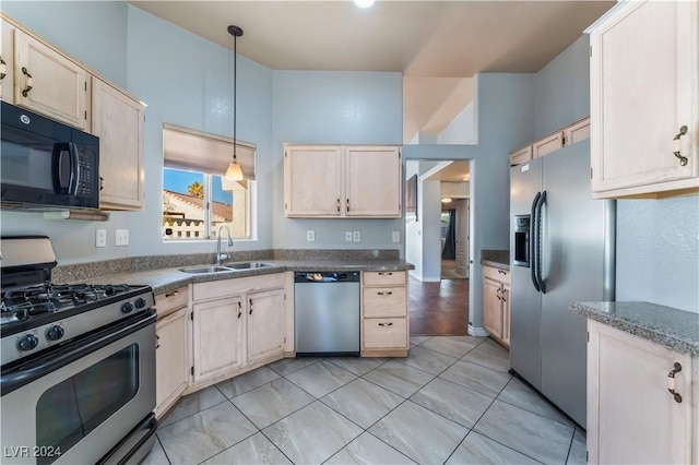 kitchen with decorative light fixtures, sink, stainless steel appliances, and light brown cabinetry