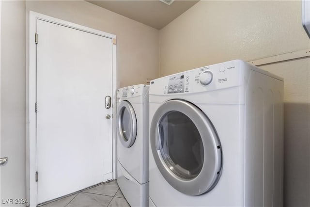 washroom with separate washer and dryer and light tile patterned floors