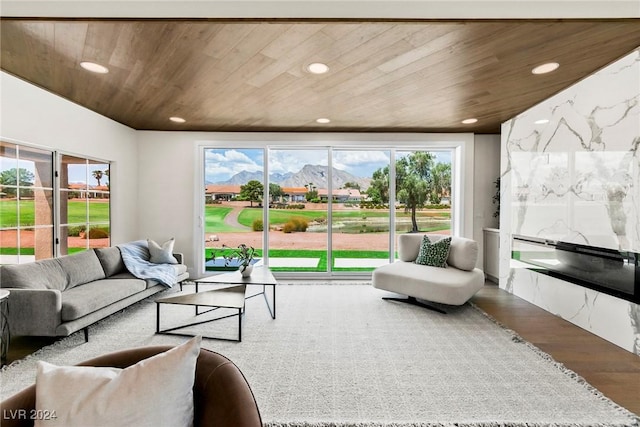 living room with a mountain view, hardwood / wood-style flooring, and wooden ceiling