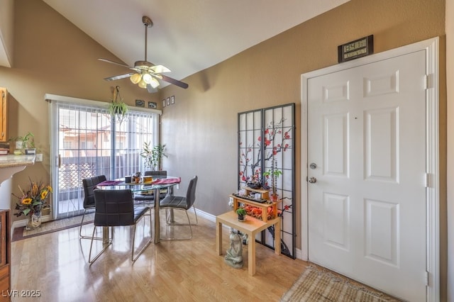 dining space featuring light hardwood / wood-style floors, ceiling fan, and vaulted ceiling