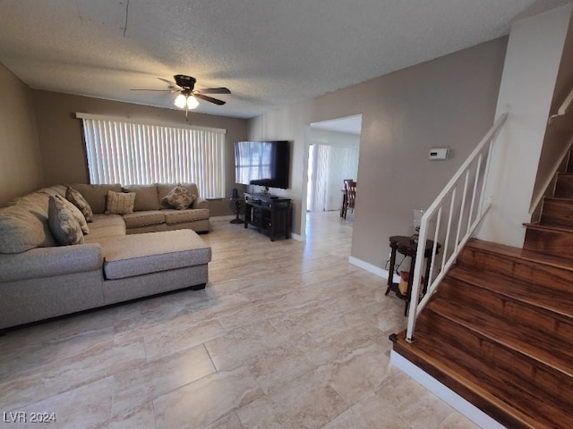 living room with a textured ceiling and ceiling fan