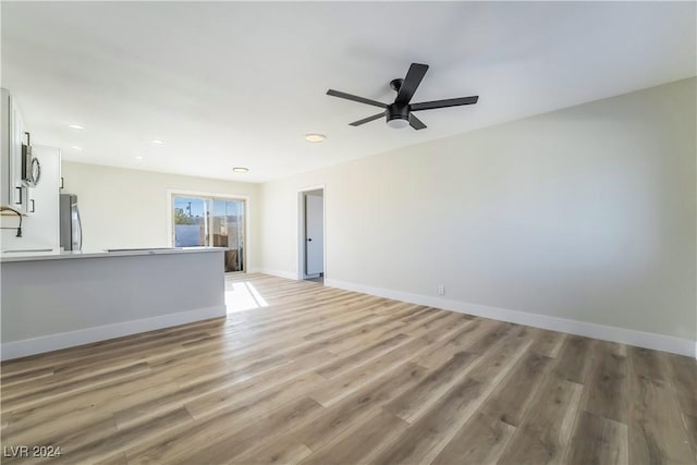 unfurnished living room with ceiling fan and light wood-type flooring