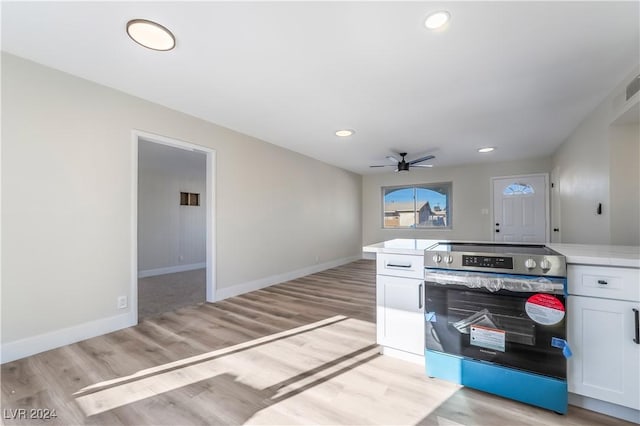 kitchen with ceiling fan, white cabinets, stainless steel electric range, and light wood-type flooring