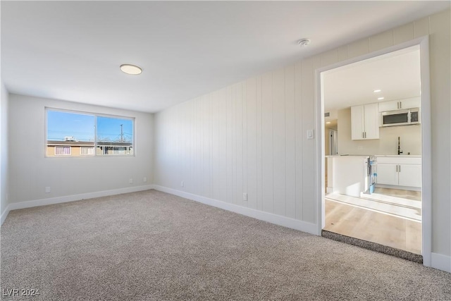 spare room featuring carpet flooring and sink