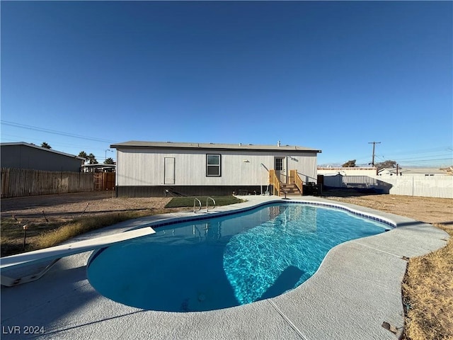 view of swimming pool featuring a diving board