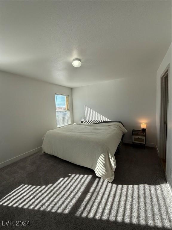 bedroom with dark colored carpet