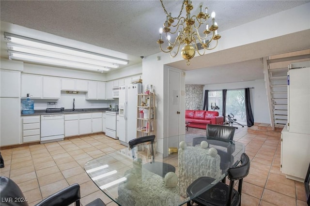 kitchen featuring white cabinets, light tile patterned floors, white appliances, and a notable chandelier