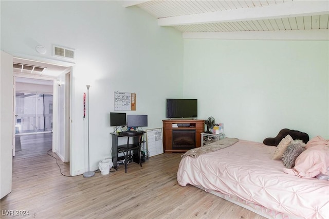 bedroom featuring hardwood / wood-style floors, vaulted ceiling with beams, and wooden ceiling