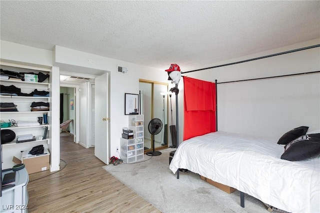 bedroom featuring wood-type flooring and a textured ceiling