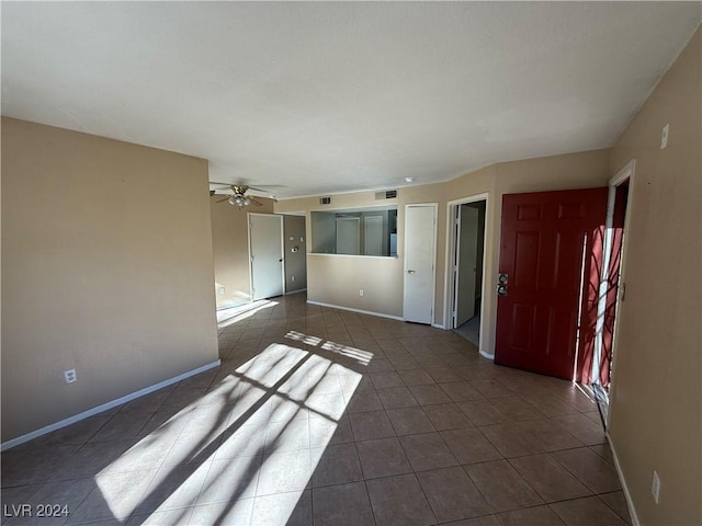 unfurnished room featuring dark tile patterned floors and ceiling fan