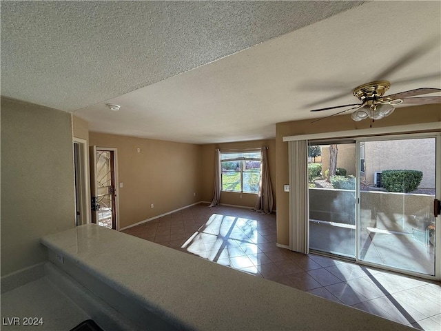 unfurnished room featuring tile patterned flooring, ceiling fan, and a textured ceiling