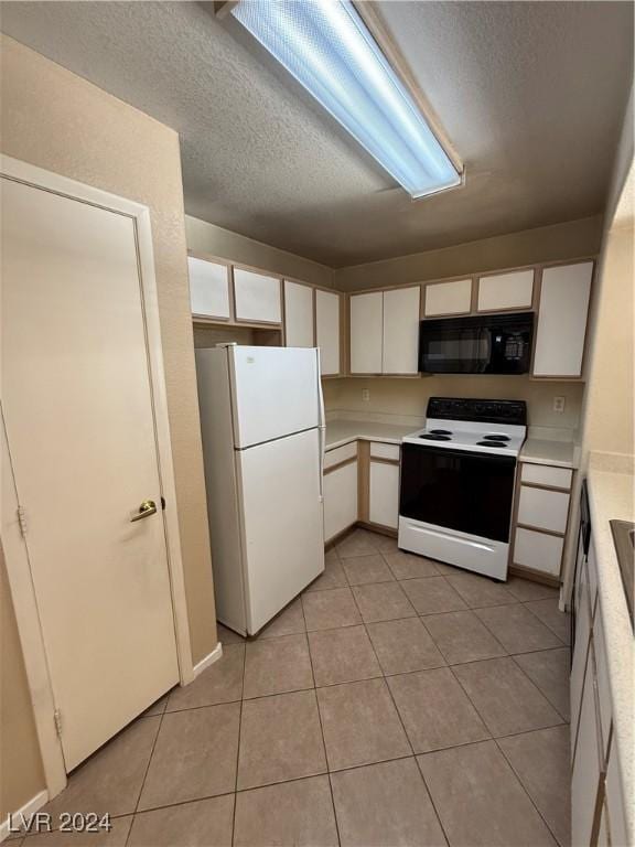 kitchen featuring white cabinetry, white appliances, a textured ceiling, and light tile patterned floors