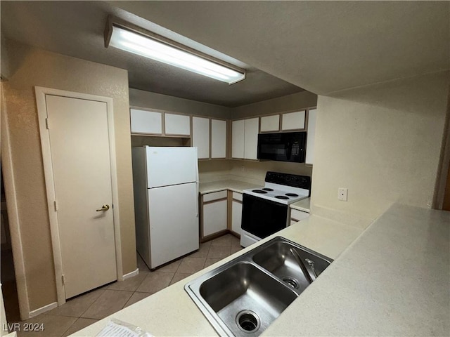 kitchen featuring white cabinetry, sink, light tile patterned flooring, and white appliances