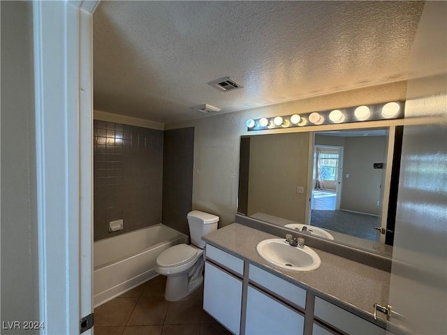 full bathroom featuring tile patterned flooring, a textured ceiling, toilet, vanity, and tiled shower / bath