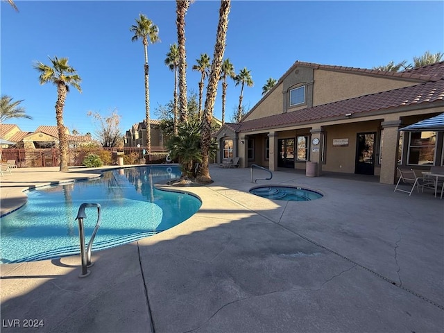 view of pool with a hot tub and a patio area