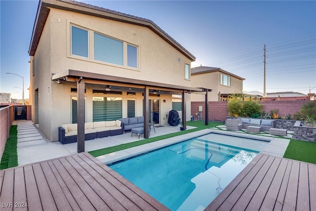 back of property with a fenced in pool, a patio area, and an outdoor hangout area