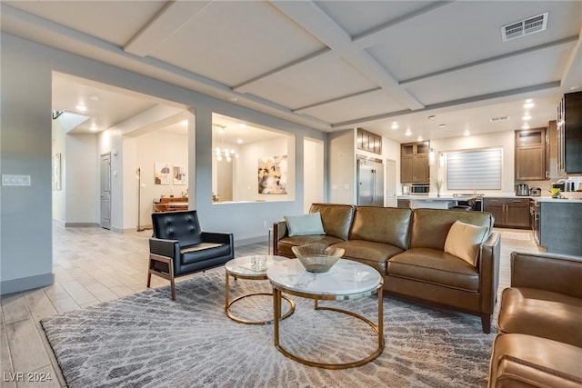 living room featuring a chandelier, light wood-type flooring, and coffered ceiling