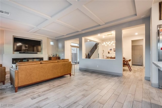 living room with an inviting chandelier, light wood-type flooring, and coffered ceiling