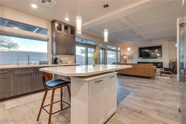 kitchen with a wealth of natural light, pendant lighting, and light hardwood / wood-style floors