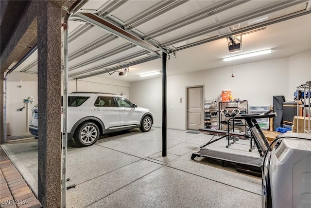 garage featuring a carport, a garage door opener, and washer and clothes dryer