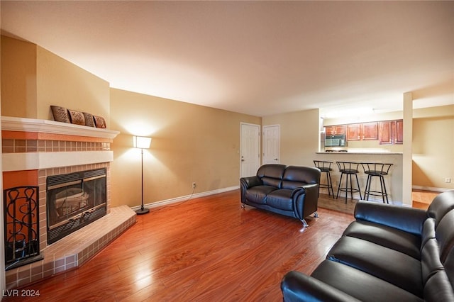 living room with light hardwood / wood-style floors and a brick fireplace