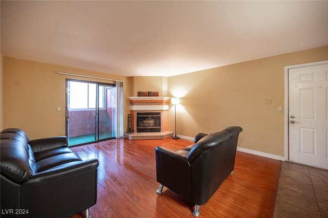 living room with hardwood / wood-style flooring and a brick fireplace