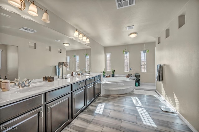 bathroom featuring tile patterned floors, vanity, and a bathing tub