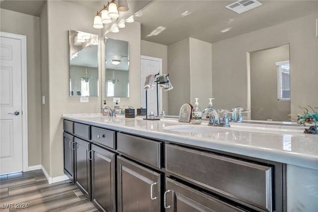 bathroom featuring wood-type flooring, vanity, and an inviting chandelier